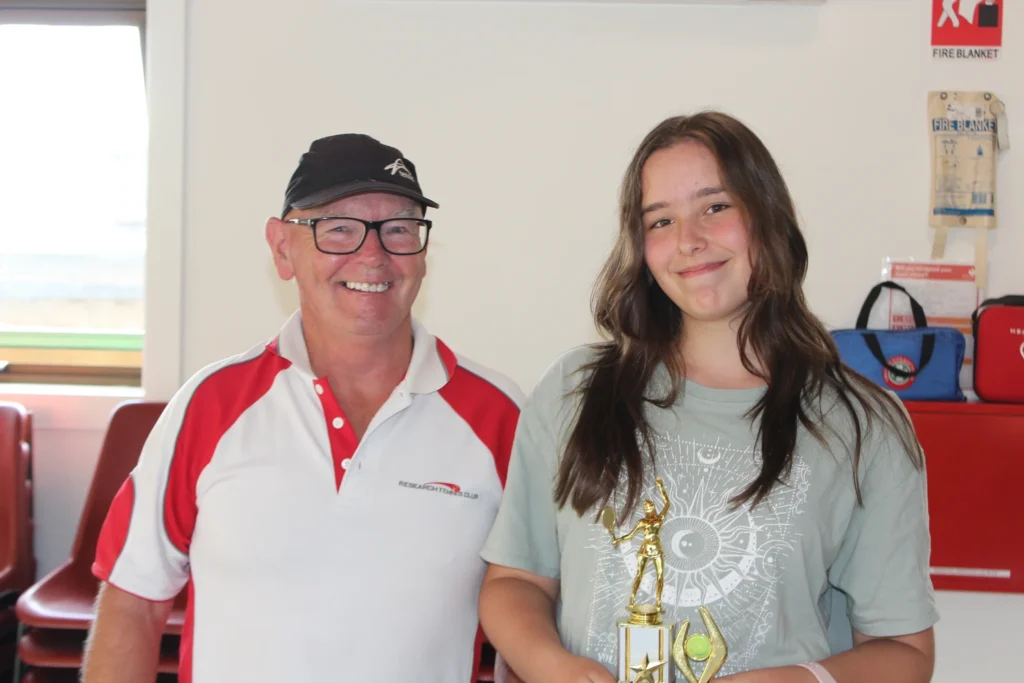 Mike Paterson awarding tennis trophy to Sienna Evans, Junior Girls Singles winner